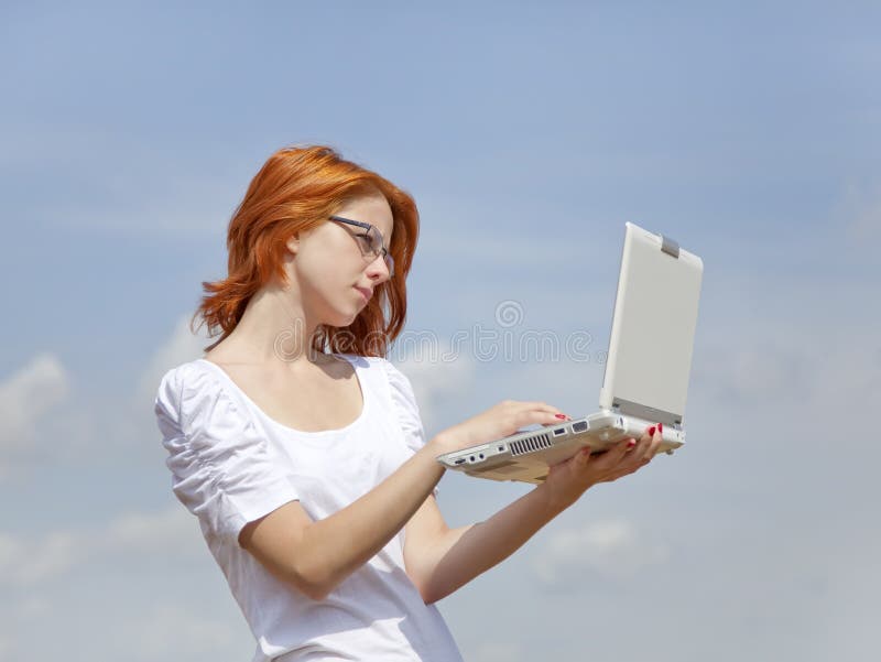 Young Businesswomen in white keeping laptop