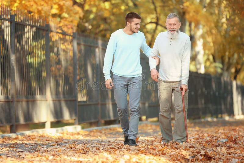 Young Caregiver Walking with Senior Man Stock Image Image of people