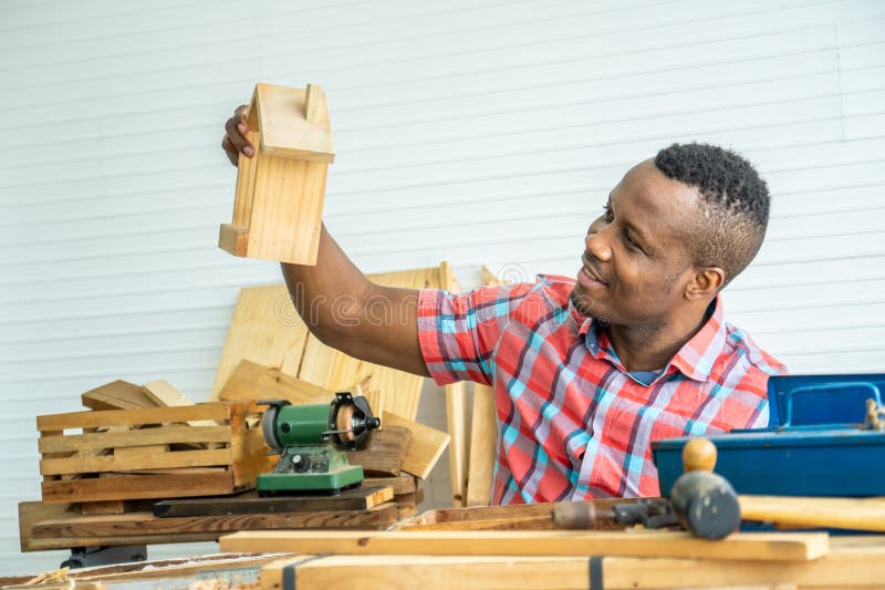 African American Male Carpenter Sitting at Table Showing Model Car