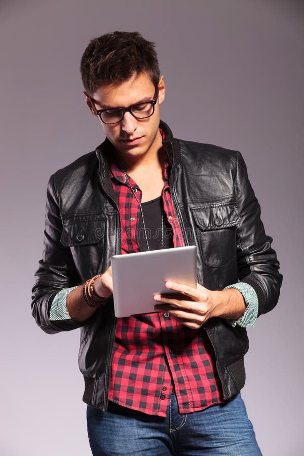 Young casual man with glasses working on tablet royalty free stock images Young casual man with glasses working on tablet royalty free stock images