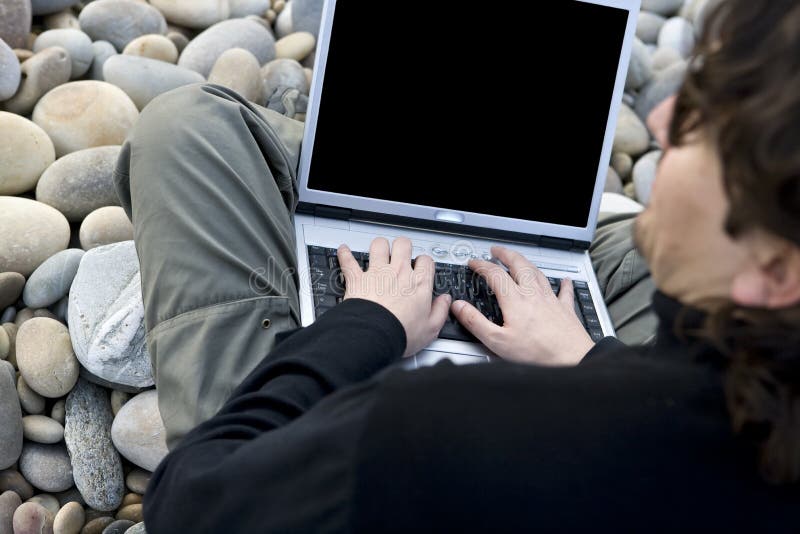 Young casual man with laptop computer in the beach