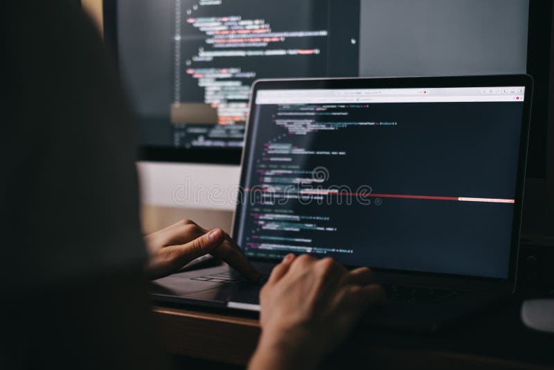 Young caucasian female programmer in glasses writes program code on a laptop royalty free stock images