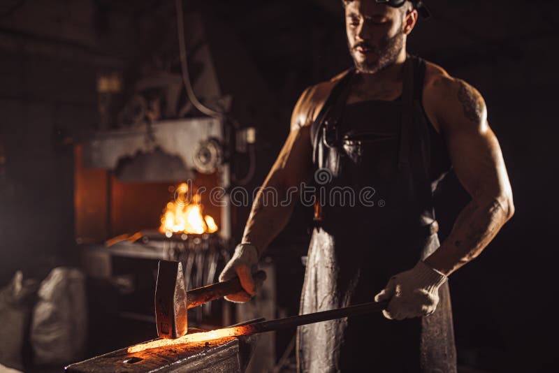Young caucasian man beating hot metal royalty free stock photography