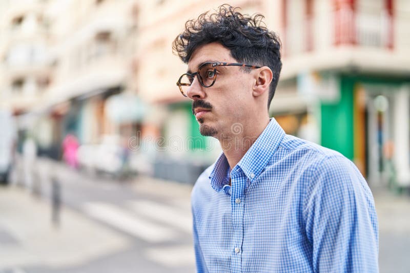 Young caucasian man looking to the side with serious expression at street stock photo