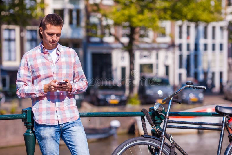 Young caucasian man with phone in european city