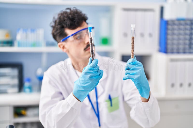Young caucasian man scientist holding test tubes at laboratory stock images