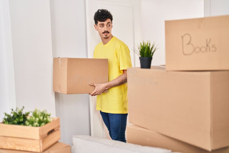 Young caucasian man smiling confident holding package at new home royalty free stock photography