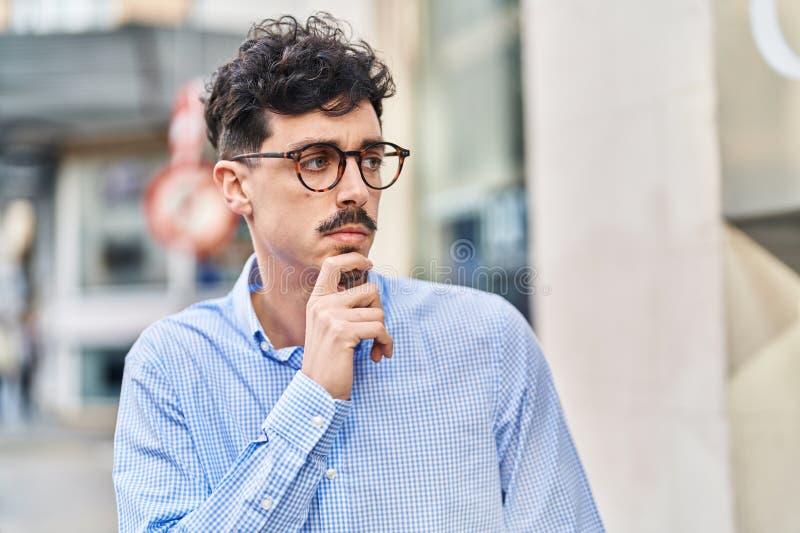 Young caucasian man standing with doubt expression at street stock photography