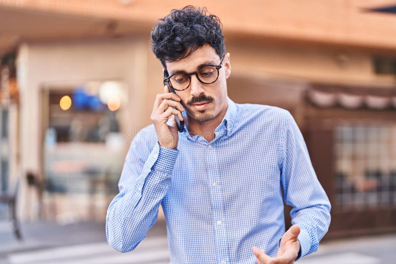 Young caucasian man talking on the smartphone with serious expression at street royalty free stock photos