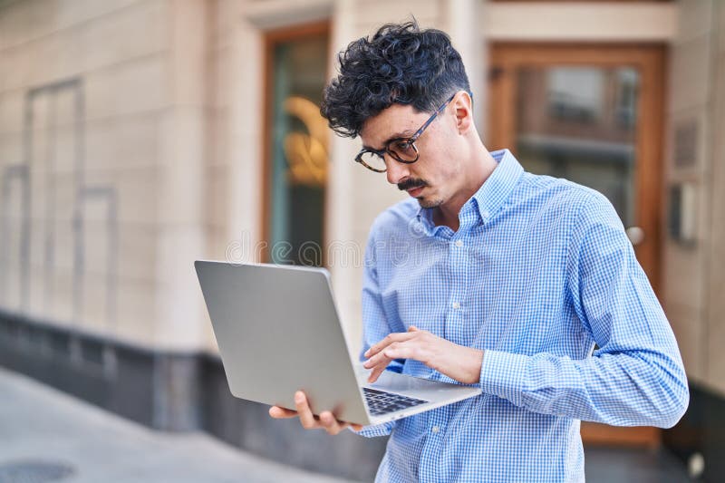 Young caucasian man using laptop standing at street stock images