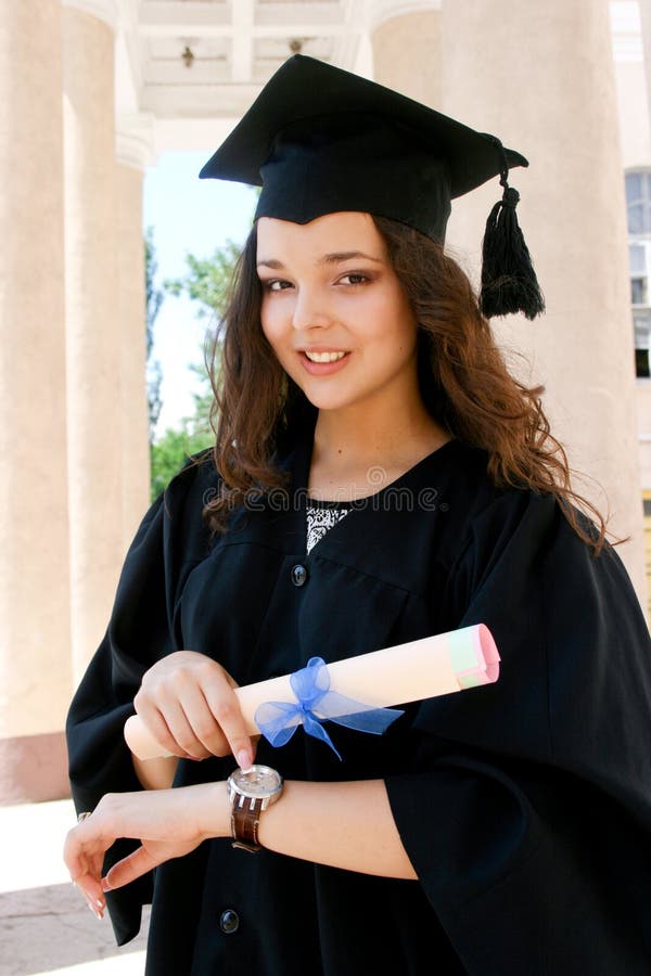 Young caucasian student in gown with watch