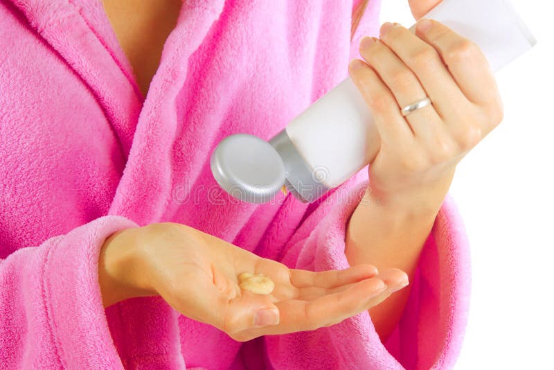 Young Caucasian woman applying creme on her hand