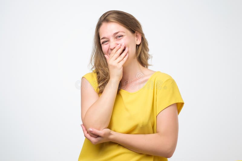 Young caucasian woman closing her mouth and wide open eye isolated on white background. She is surprised by unexpected pleasant news. I can not keep it a secret