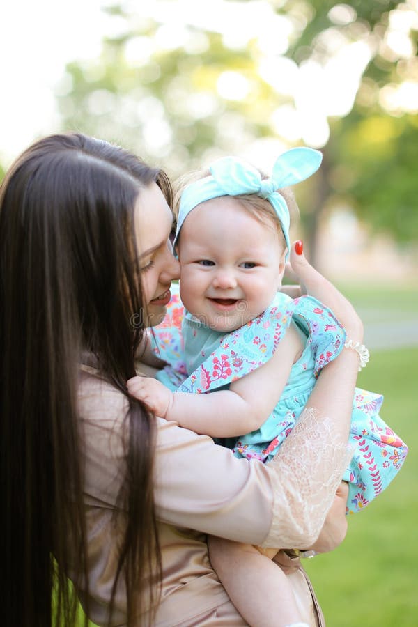 Young Caucasian Woman Holding Little Daughter in Green Background ...