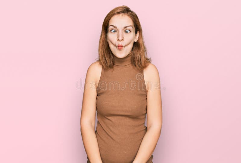 Young caucasian woman wearing casual clothes making fish face with lips, crazy and comical gesture