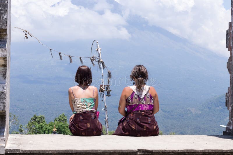 Young caucasian women tourist near the balinese hindu temple. The volcano Agung on the background. Rare view. Bali royalty free stock photos Young caucasian women tourist near the balinese hindu temple. The volcano Agung on the background. Rare view. Bali royalty free stock photos