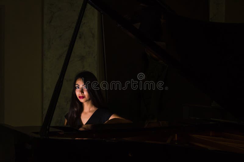 Young charming brunette girl playing the piano stock photography Young charming brunette girl playing the piano stock photography