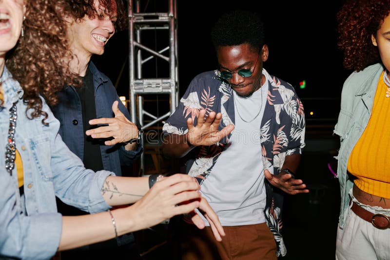 Young cheerful multicultural people in stylish casualwear enjoying dancing royalty free stock images