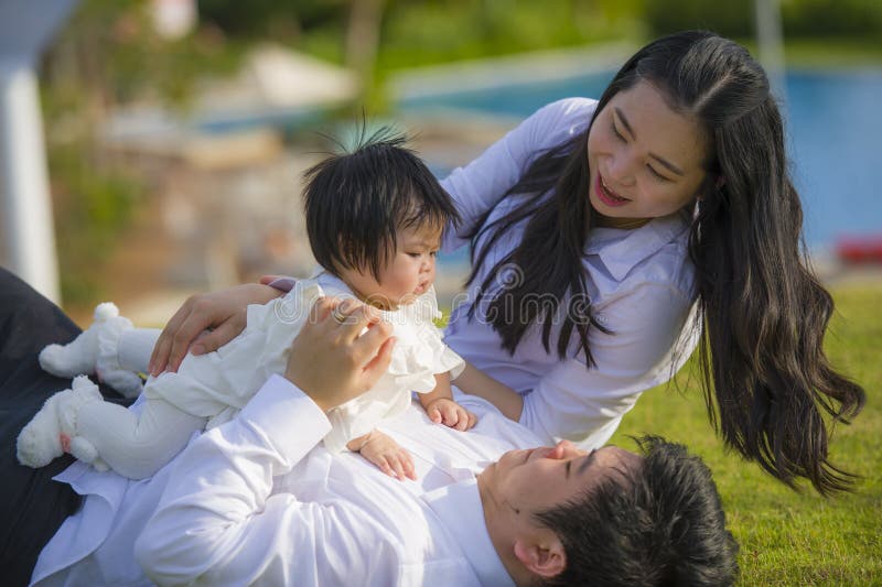 Young Cheerful and Sweet Wife and Husband Couple with Mother and Father Playing with Little Daughter in Asian Korean Family Stock Photo