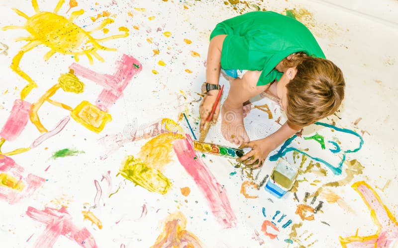 Young child boy painting over white