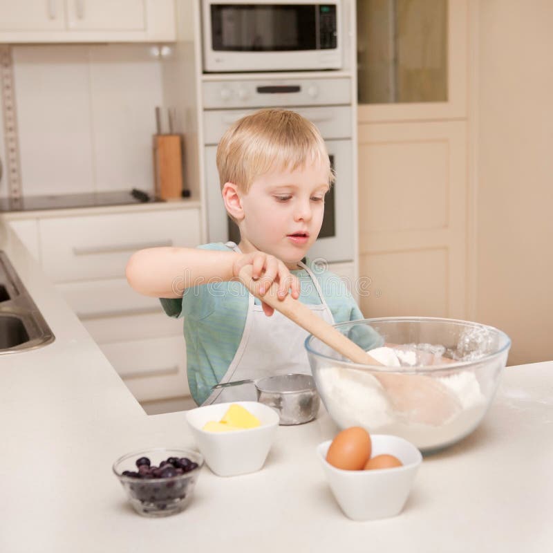 A Young Child is Cooking in a Domestic Kitchen. Stock Image - Image of