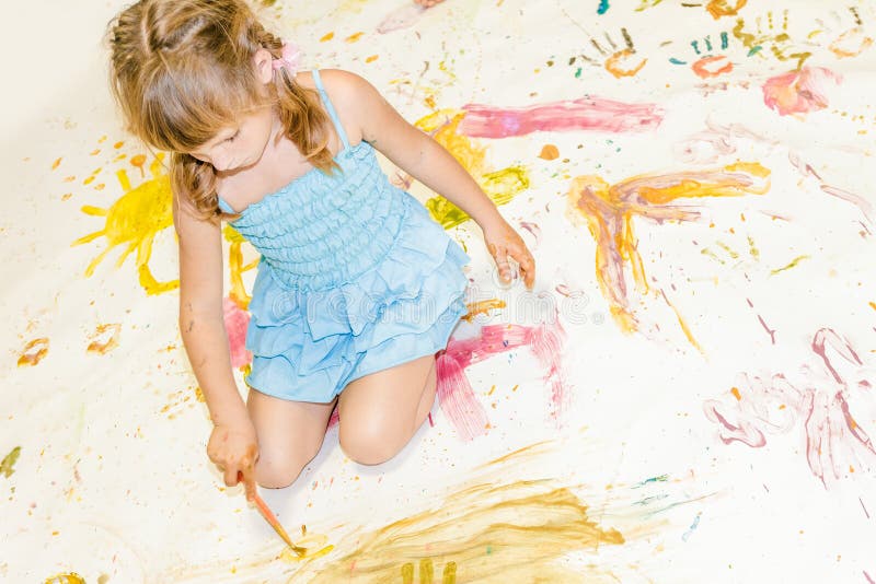 Young child girl painting over white