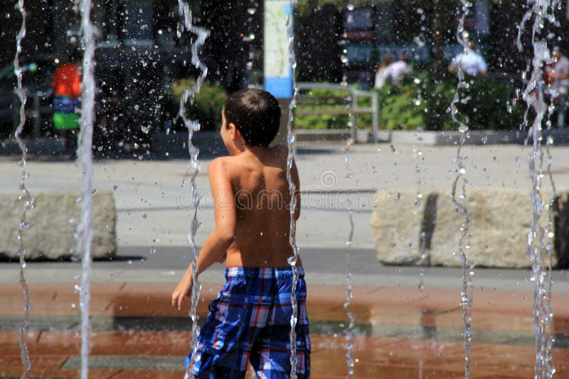 Young child having fun in water fountain,Boston Mass,Summer,2013