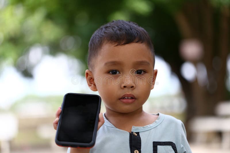 Young Child Holding a Smartphone in Nature Setting royalty free stock images
