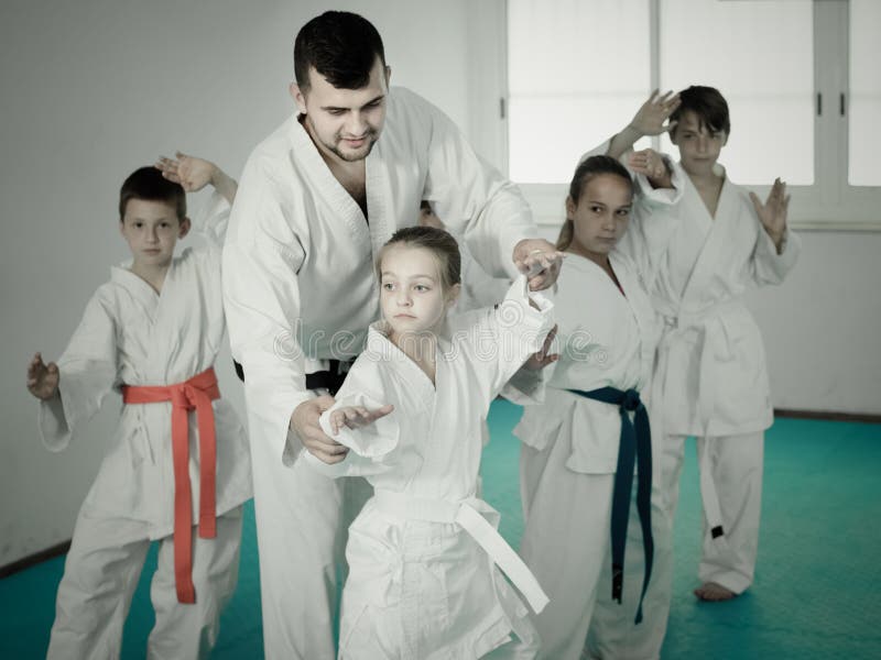 Young children doing karate kicks with male coach royalty free stock image Young children doing karate kicks with male coach royalty free stock image