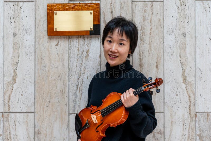 Young Chinese Female Violin Maker Showing Her Freshly Made Violin