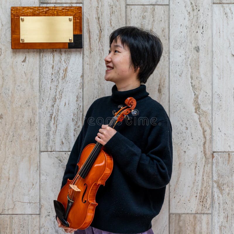 Young Chinese Female Violin Maker Showing Her Freshly Made Violin