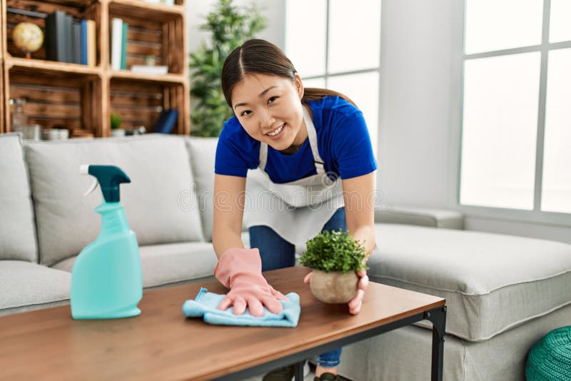 Young Chinese Housewife Cleaning Table Using Diffuser and Rag at Home