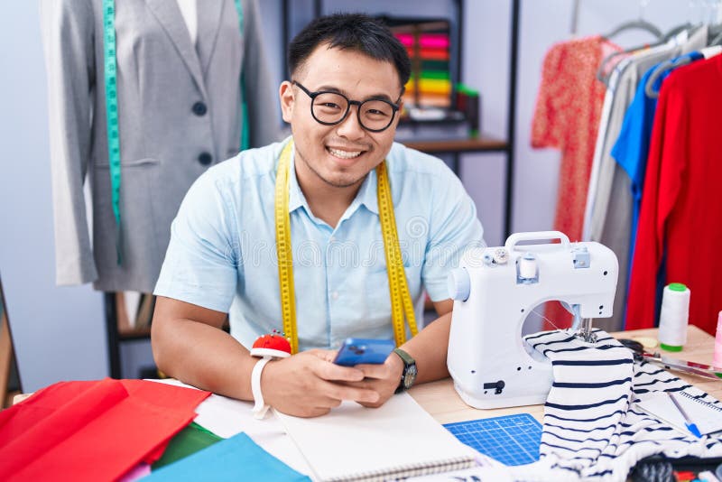 Young Chinese Man Tailor Smiling Confident Using Smartphone at Tailor ...