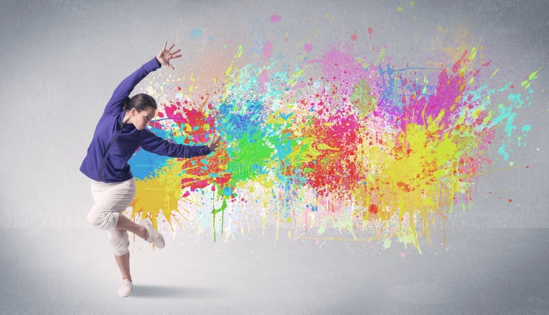 A funky contemporary hip hop dancer dancing in front of grey background with colorful bright paint splatter concept. A funky contemporary hip hop dancer dancing in front of grey background with colorful bright paint splatter concept