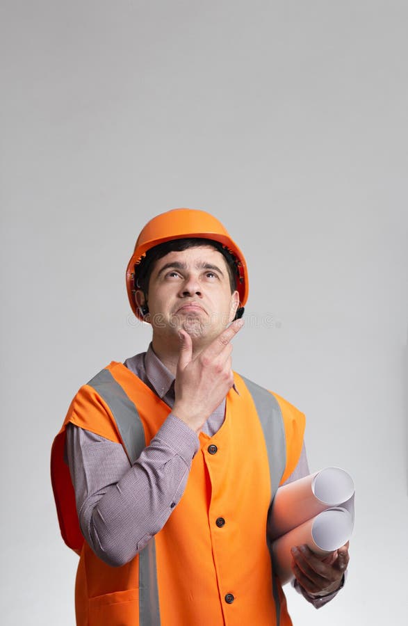 Young Construction Worker in Hard Hat and Reflective Vest Thinking with