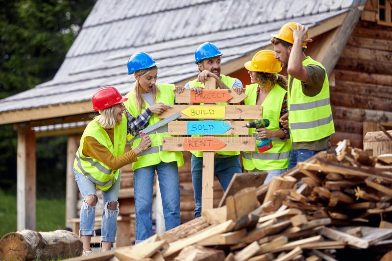 Young Construction Workers Cheering Over Wooden Table, Group Project