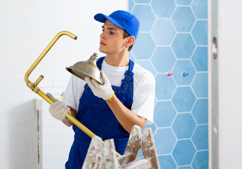 Young Contractor Preparing Shower for Installation in Building Under