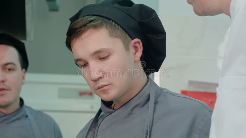 Young cook trainee tasting seafood dish