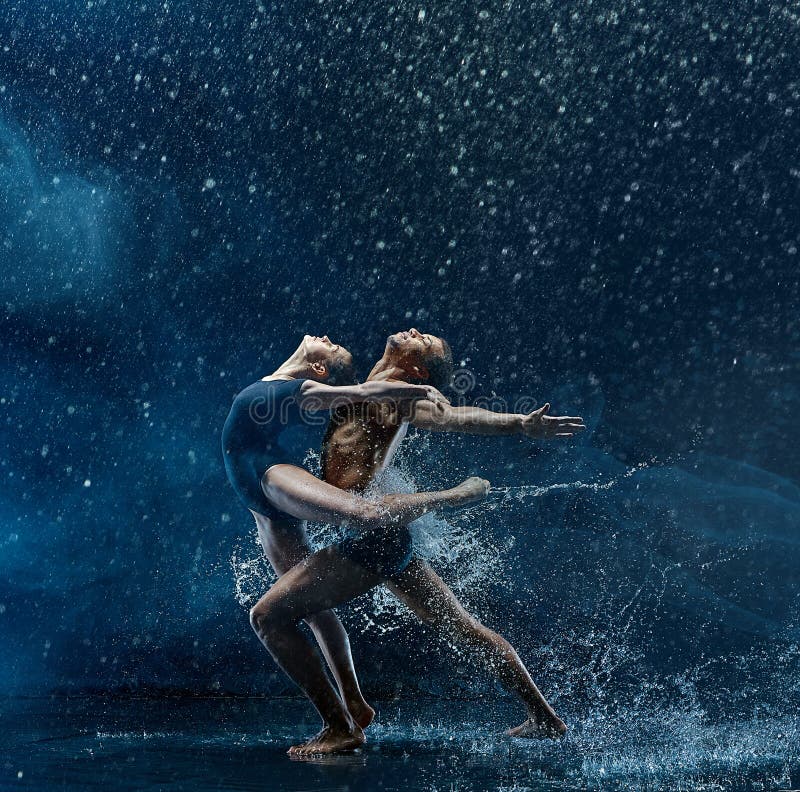 Young couple of ballet dancers dancing unde rwater drops