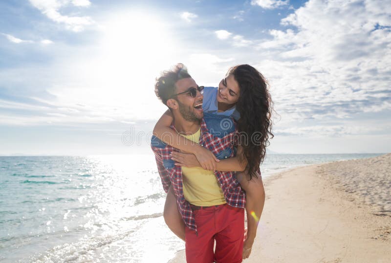 Young Couple On Beach Summer Vacation, Happy Smiling Man Carry Woman Back Seaside