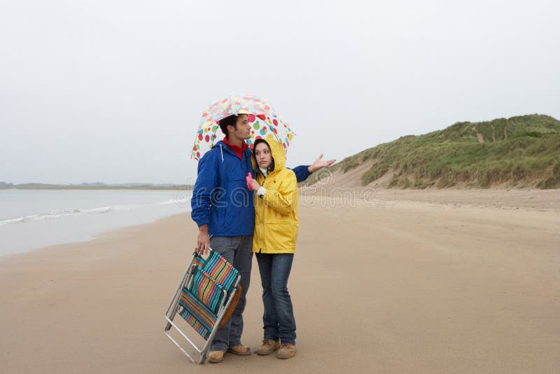 Young couple on beach with umbrella