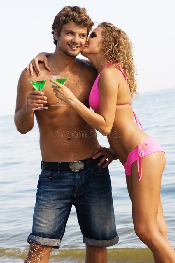 Young couple with cocktails on the seaside