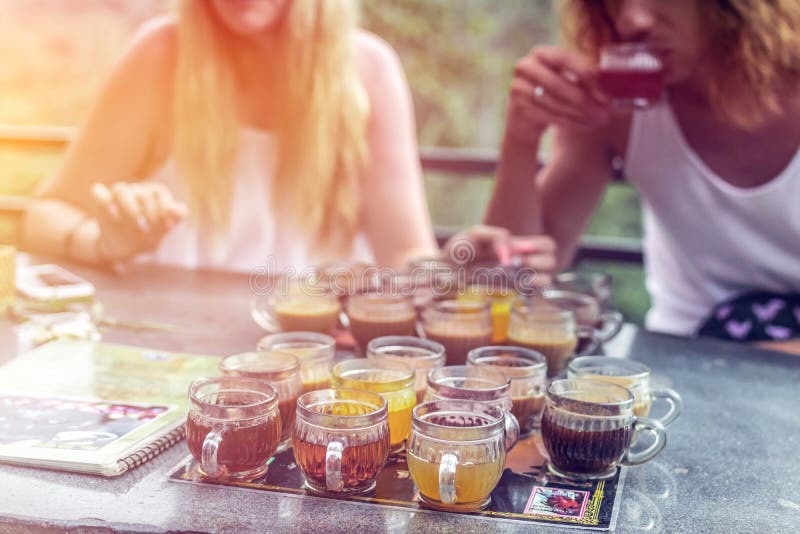 Young couple coffee and tea tasting during sunset in the jungle rainforest of a tropical Bali island.