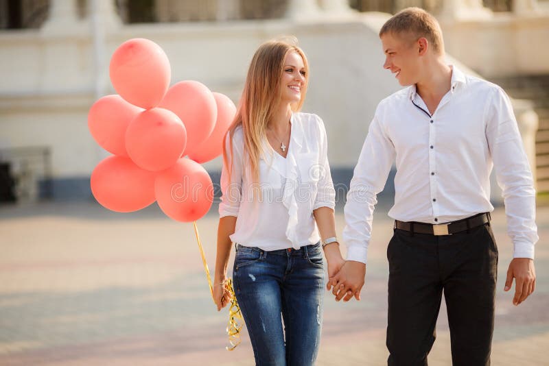 Young couple with colourful balloons in town.