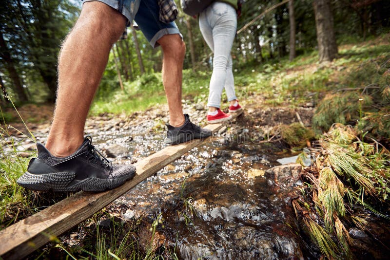 A Young Couple is Crossing a Creek while Hiking. Hiking, Nature ...