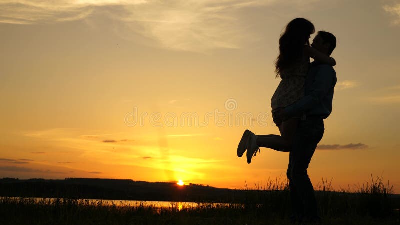 Young couple dancing at sunset on beach. Happy guy and girl waltz in evening in the summer park. Loving man and woman