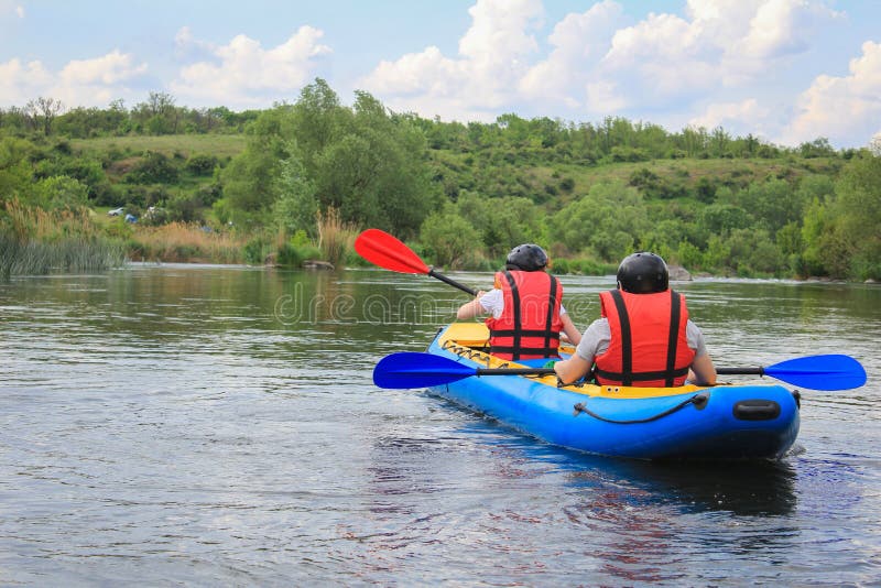 Young couple enjoy white water kayaking on the river