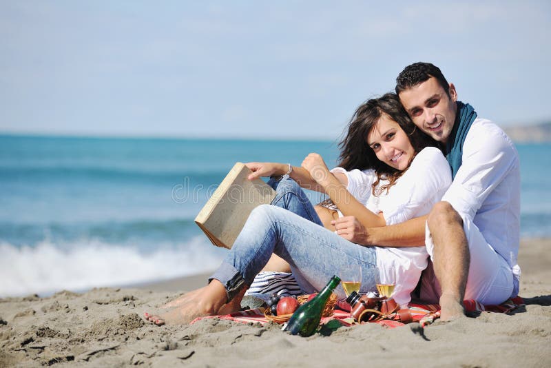 Young couple enjoying picnic on the beach