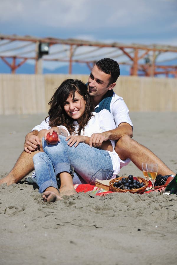 Young couple enjoying picnic on the beach