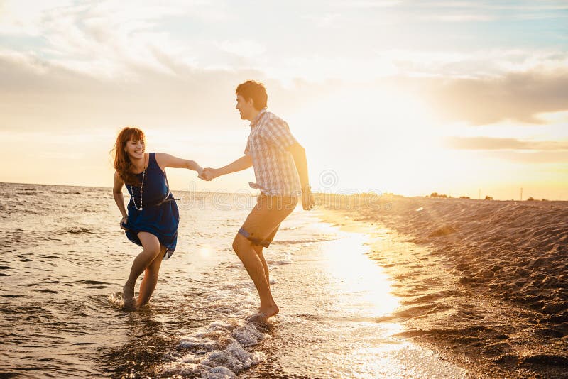 A Young Couple Enjoys A Mid Summer Late Afternoon On A Wet San Stock